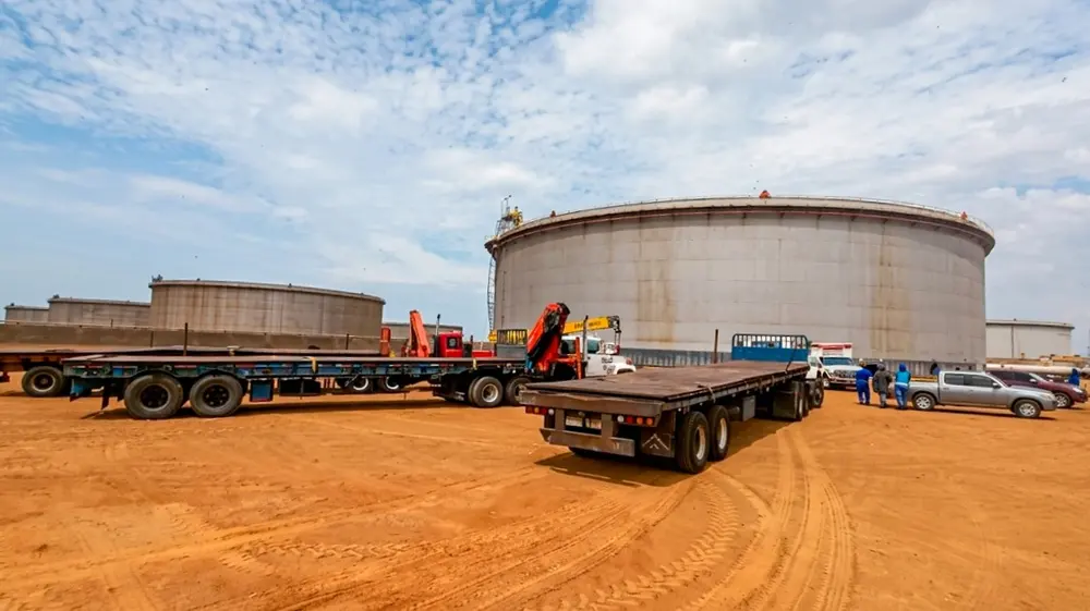 Batea transportando una sección de tanque junto al patio