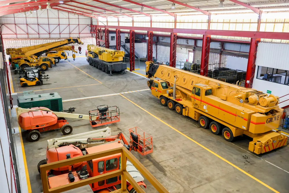 Flota de grúas y plataformas elevadoras en el galpón de New Proyect