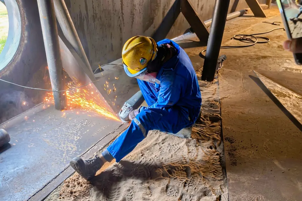 Operario cortando con oxicorte en el interior del tanque
