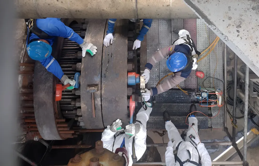 Cuadrilla con equipo de protección interviniendo un intercambiador de calor